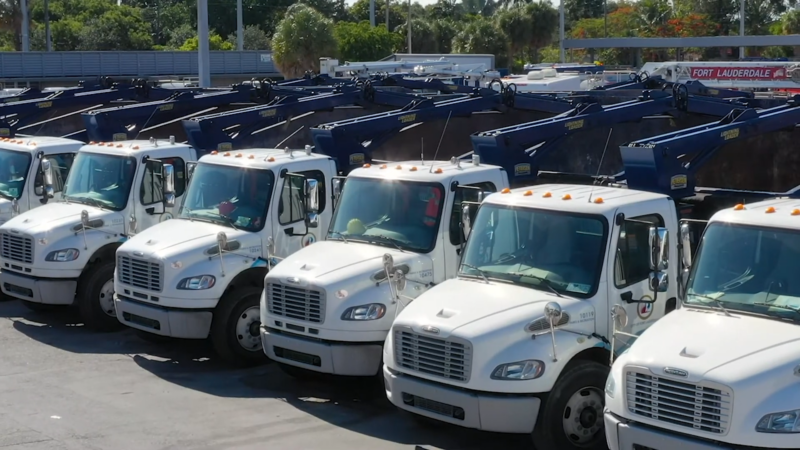 
A Line of White Commercial Trucks Parked in A Lot, Demonstrating how Trucking Companies Utilize Telematics and Gps Data to Enhance Operational Efficiency and Support Legal Cases